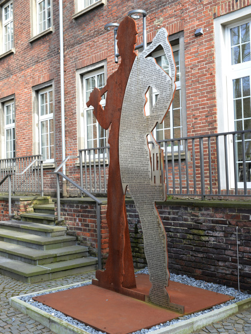 Skulptur vor der Licht und Lohnhalle, die stellvertrend für alle Bergleute dort steht und die Form eines solchen hat. Auf ihr steht ein längerer Text, der alle Bergleute würdigt.