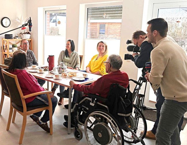 Menschen sprechen über Pflege und Alltag; ein Filmteam dokumentiert Inklusion und Unterstützung.